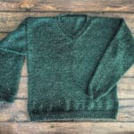 Flat lay of green knit sweater.