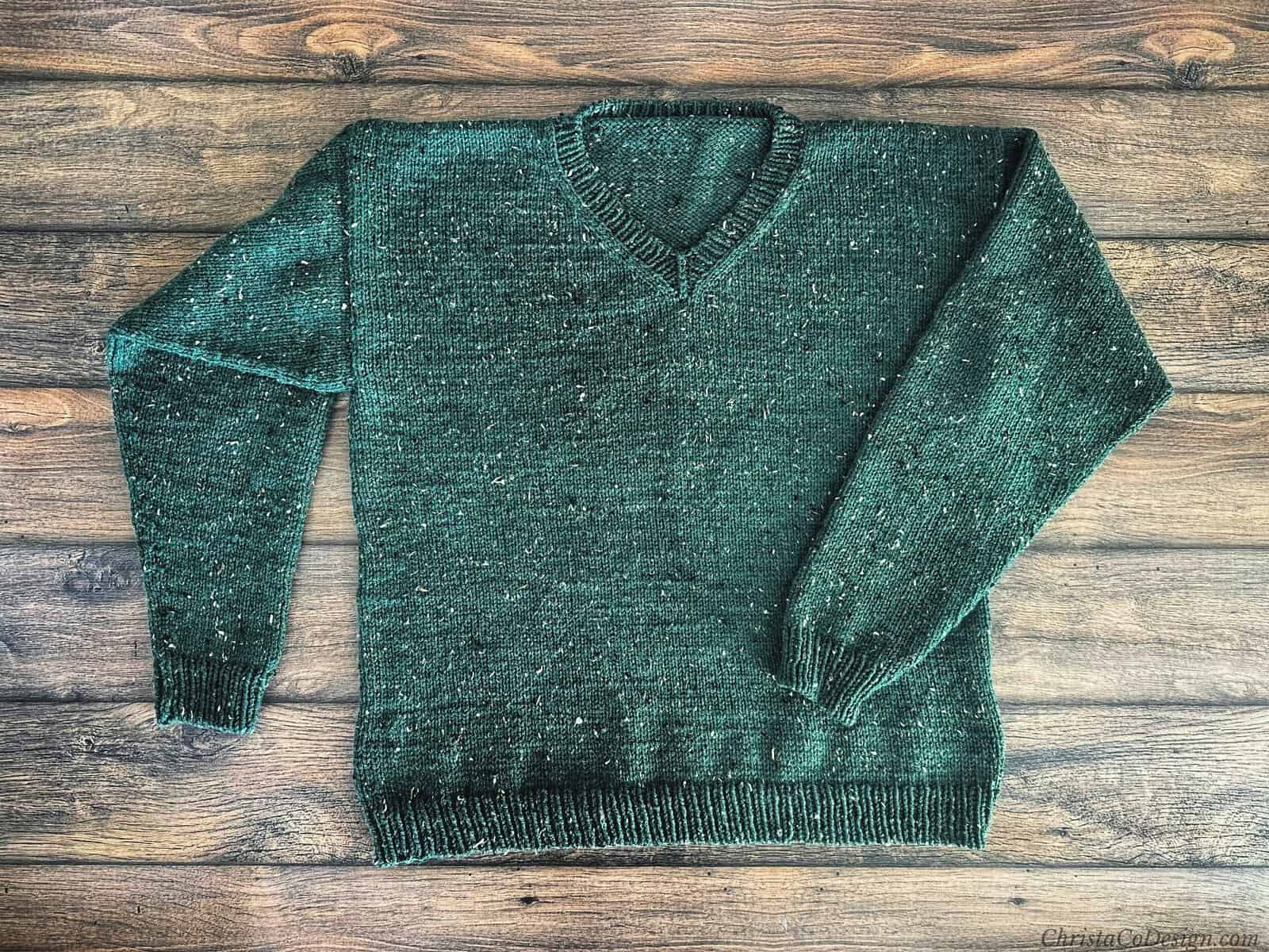 Flat lay of green knit sweater.