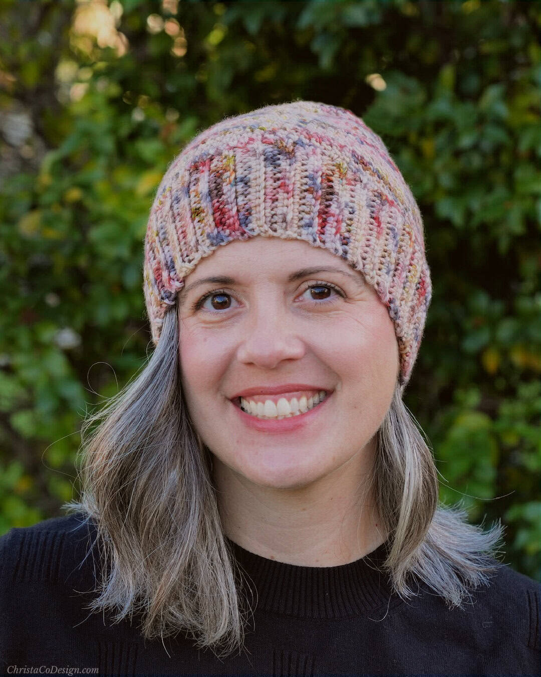 Woman smiling in crochet hat.
