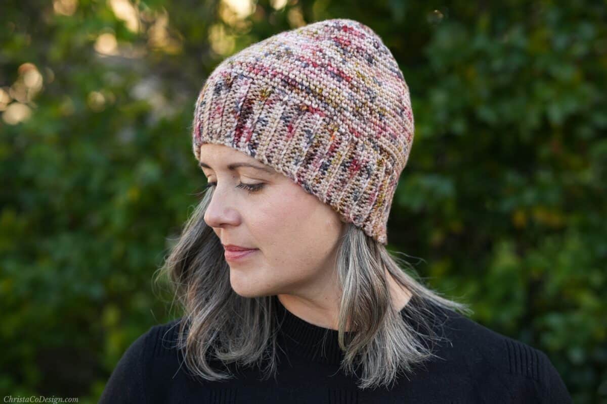 Woman in crochet beanie with head turned.
