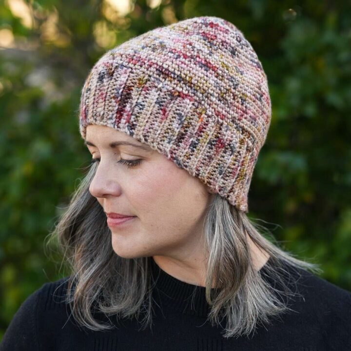 Woman in crochet beanie with head turned.