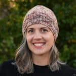 Woman smiling in fitted knit beanie.