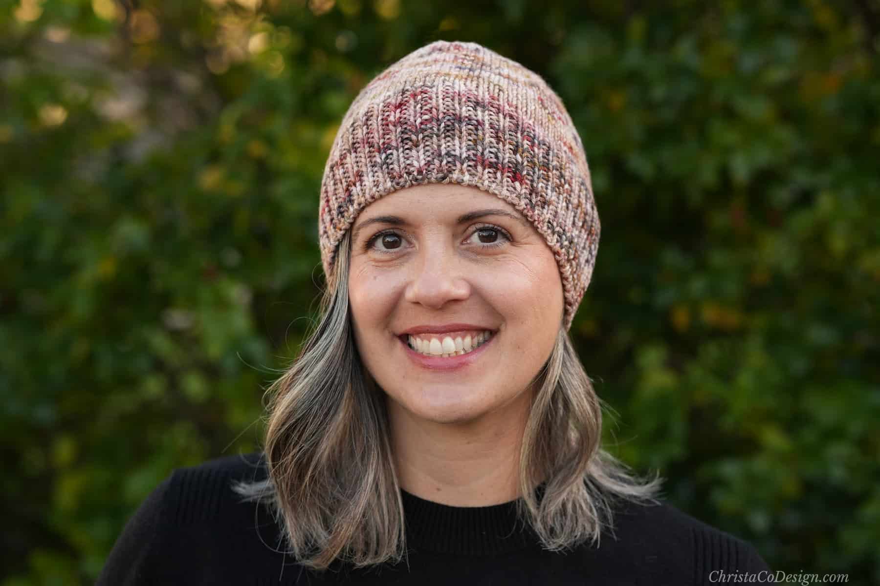 Woman smiling in fitted knit beanie.