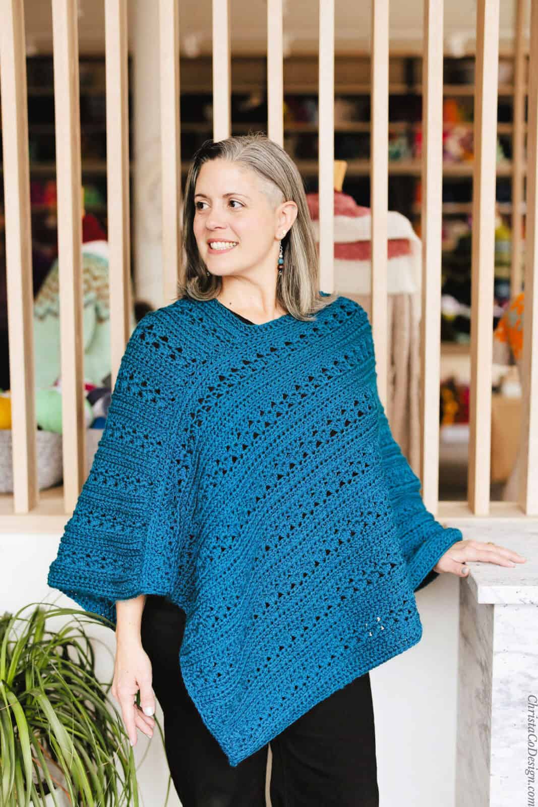 Woman looking to side in blue poncho.