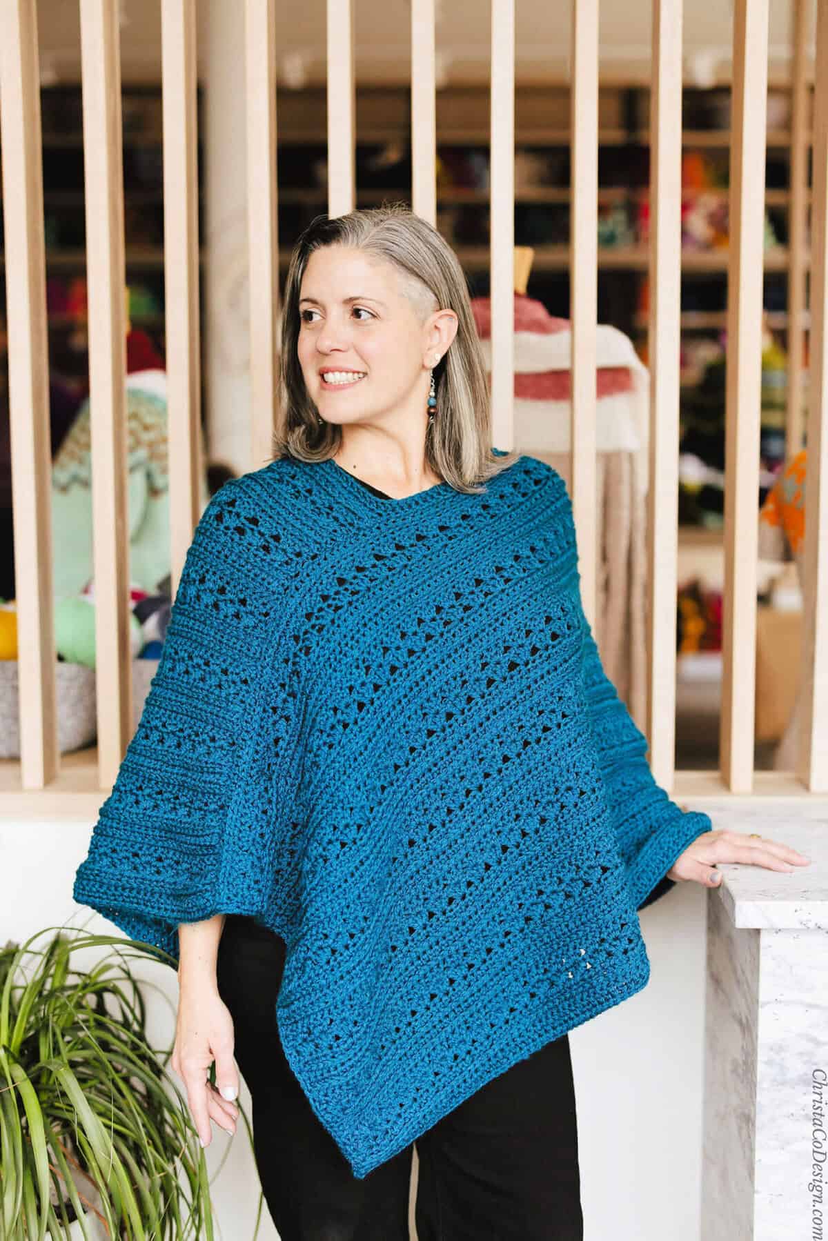 Woman looking to side in blue poncho.
