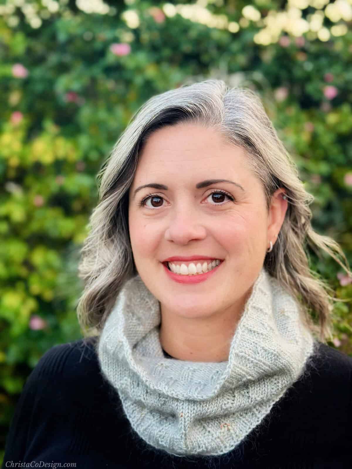 Woman smiling in silver knit cowl.