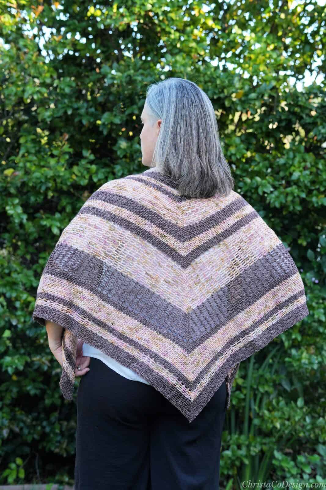 Back view of crochet triangle shawl in pinks and brown.