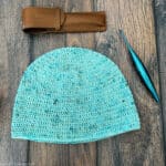 Flat lay of crochet hat with hook and case.