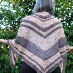 Woman with triangle shawl in pink and brown hand dyed yarn.