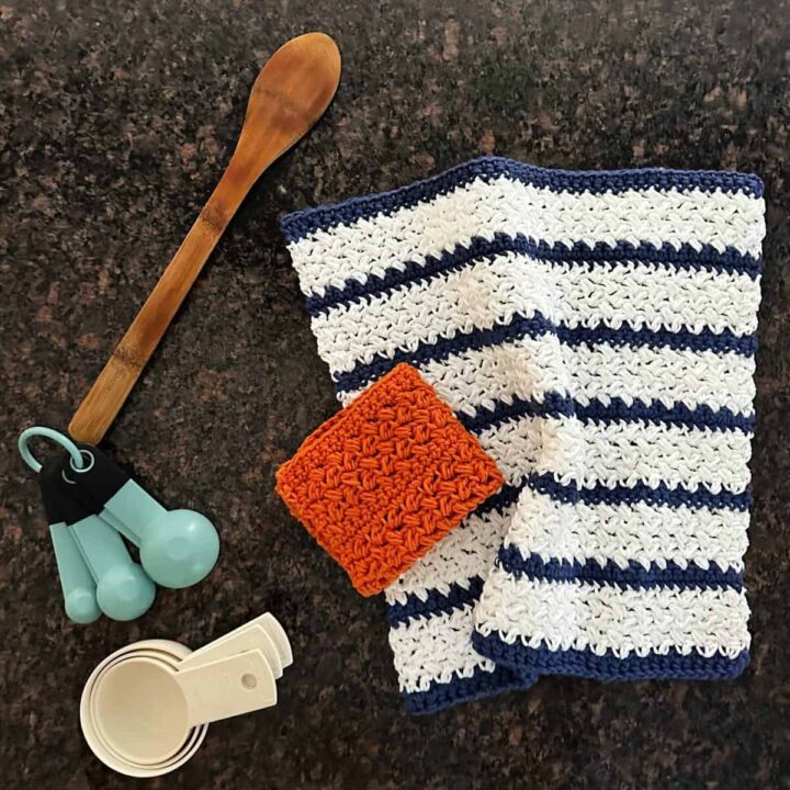 Crochet dish cloth in blue and white and an orange square with kitchen utensils.