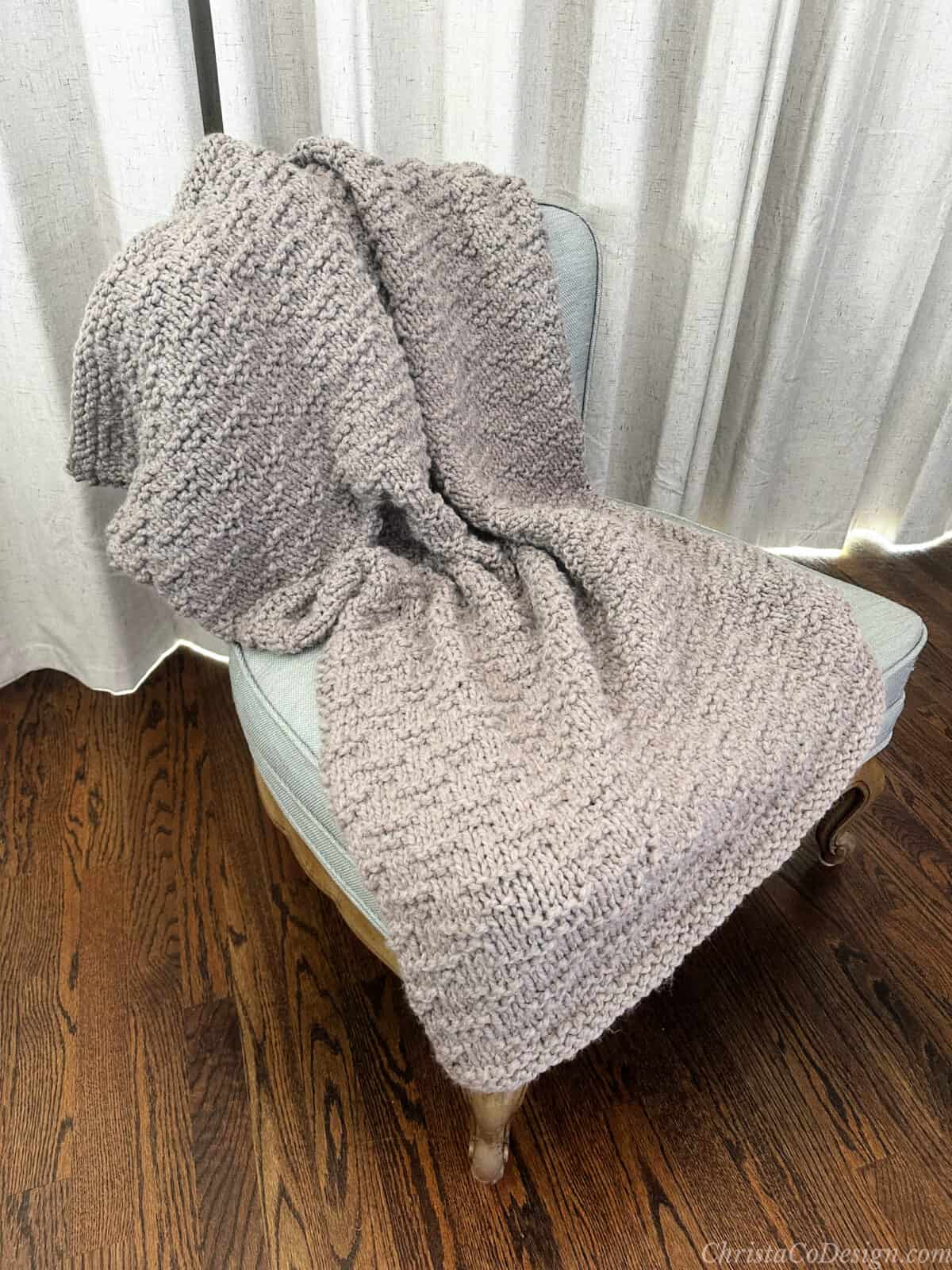 Chunky textured blanket draped on chair.