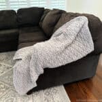 Beige throw blanket on edge of couch.