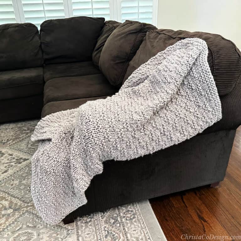 Beige throw blanket on edge of couch.