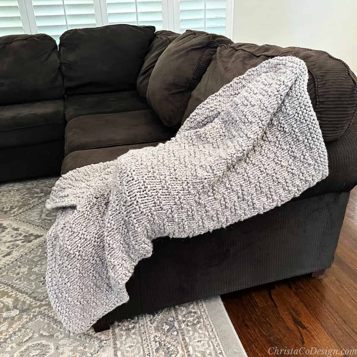 Beige throw blanket on edge of couch.
