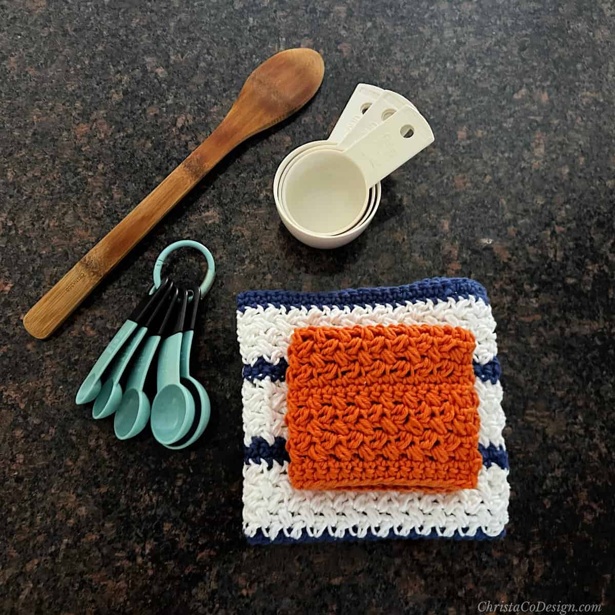 Kitchen utensils next to folded dishcloths with white and blue stripes.