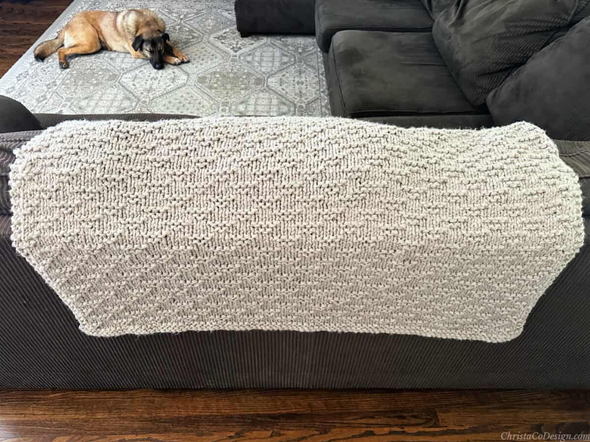 Knit blanket draped on back of couch.