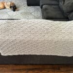 Knit blanket draped on back of couch.