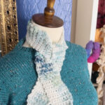 Crochet neck scarf on mannequin with blue knit sweater on.