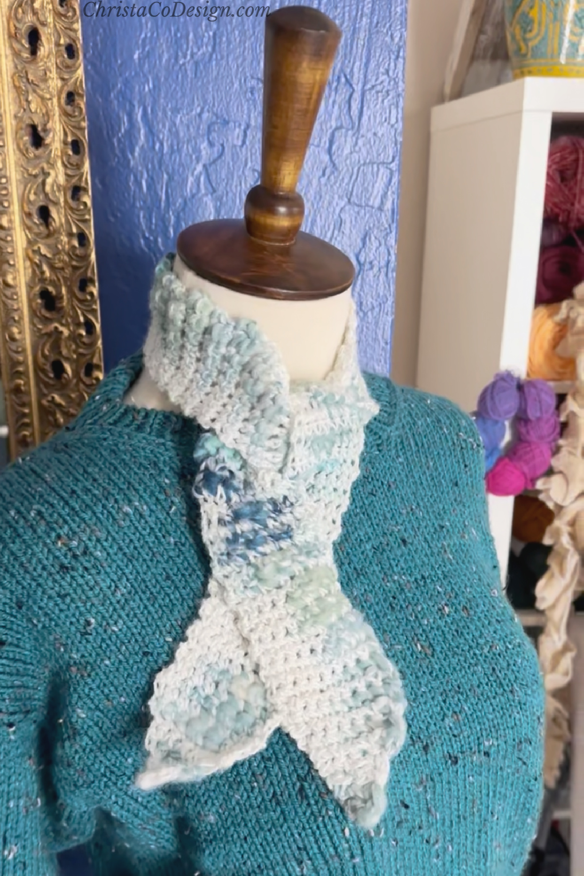 Crochet neck scarf on mannequin with blue knit sweater on.