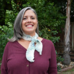 Woman wearing crochet skinny neck scarf.