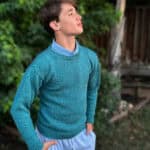 Young man in blue knit sweater looking up.