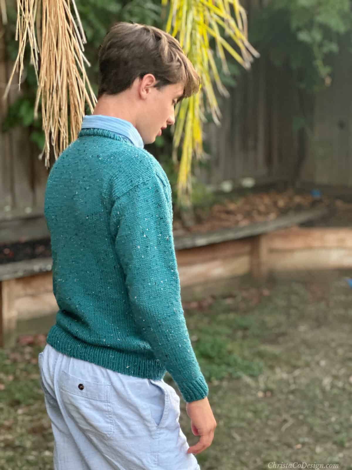 Side view of man in blue knit sweater.