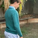 Side view of man in blue knit sweater.