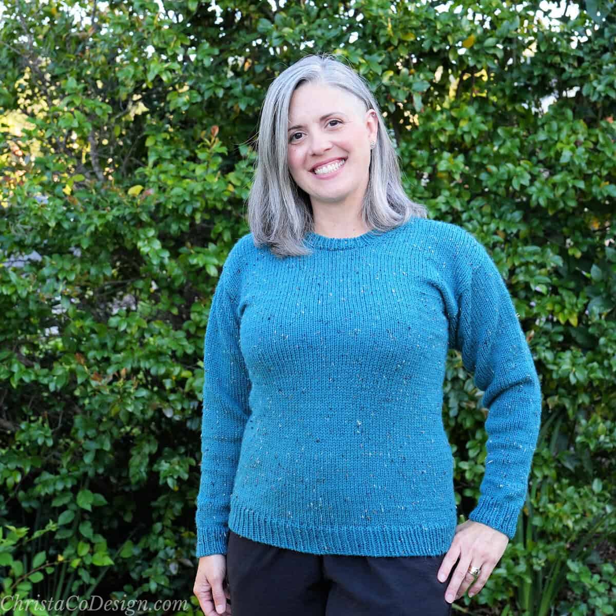 Woman in fitted blue knit sweater.