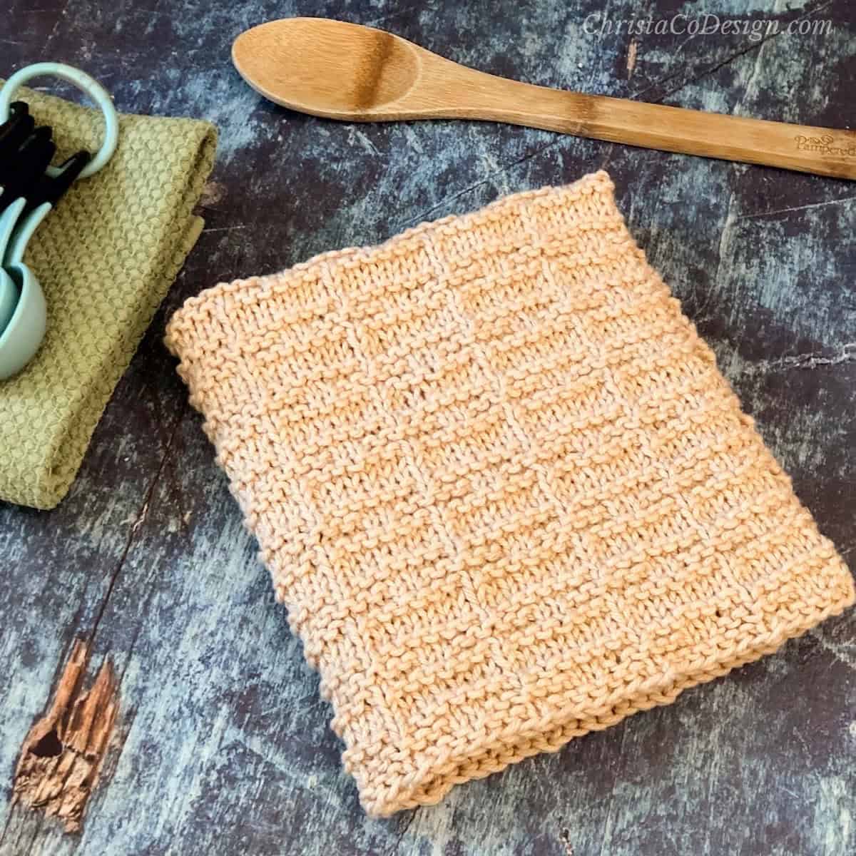 Knit towel folded next to spoons.