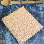 Folded dish towel next to kitchen spoon.