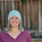 Woman in blue and white beanie smiling.