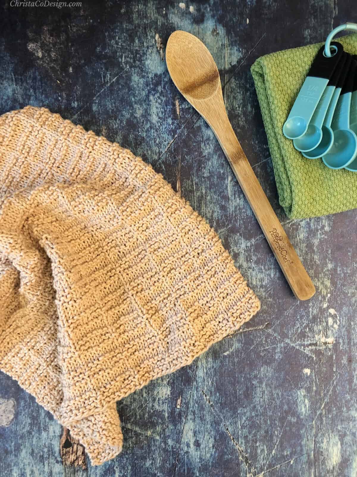 Textured towel in beige with wooden spoon.