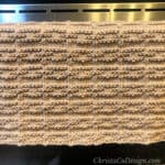 Textured dish towel draped over oven handle.